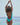 Back view of model wearing open-back structured turquoise-red swimsuit.