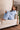 Pale blue wide leg lounge pants shown seated, showing brushed fabric drape and fit at the leg