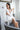 Model wearing Aspen Dream Nora Short Robe in ivory, showing front lace panels and sewn-in belt.