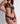 Close-up of black sheer floral lace triangle bra with gold button openings and satin ribbon tie