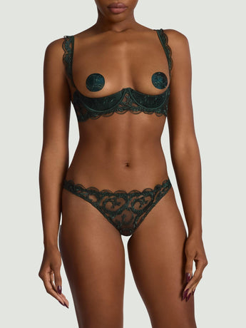 Woman wearing the Coco de Mer Arletta quarter cup bra with matching embroidered thong in emerald green.