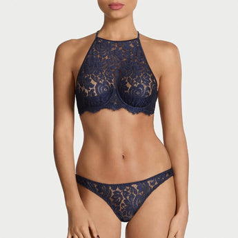 Woman wearing the Coco de Mer Tamara high neck lace bustier with matching Brazilian brief in sapphire blue French Leavers lace.