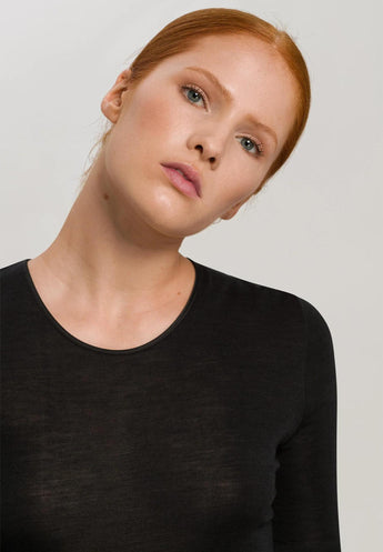 Model wearing a long-sleeve wool-silk thermal top in black by Hanro