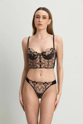 Model wearing the I.D. Sarrieri Love Potion Underwired Half Cup Bustier in black featuring embroidered tulle, stretch silk, underwired half cups, adjustable straps, and a longline silhouette.