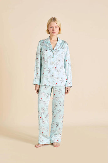 model wearing the Lila Serafina blue pajama set by Olivia von Halle with a button-up top and contrast piping