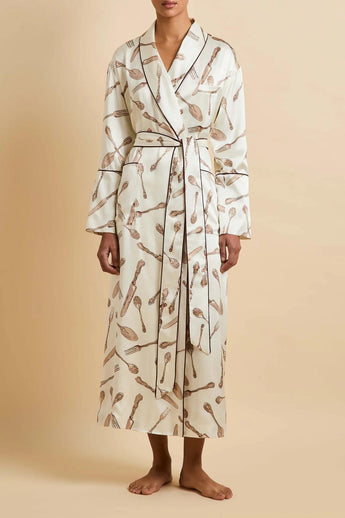 Model wearing the Olivia von Halle Capability Sevilla Cream Silverware silk robe featuring the exclusive Silverware print on cream silk satin with burgundy contrast piping and a matching self-tie belt.