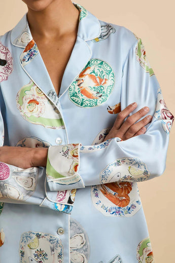 Close-up of the Olivia von Halle Lila Cadiz Blue Seafood silk pajama shirt highlighting the seafood print, ivory contrast piping, signature buttons, and luxurious 19 momme silk satin.