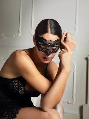 Black lace-effect eye mask with open eyes, rhinestone details, and satin tie closure for a seductive, elegant finish.