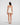 Back view of model wearing Oscalito wool and silk V-neck camisole in ivory with satin trim highlighting seamless construction.