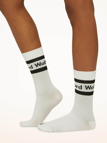 Model wearing Wolford Logo Ribbed Socks in white showing ribbed texture and blac logo detail around ankle