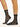 Model wearing Wolford Net Socks in black showing grid net pattern and ankle length