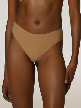 Front view of the Wolford Pure String in Fairly Light featuring a seamless no-show thong design with a smooth stretch finish.