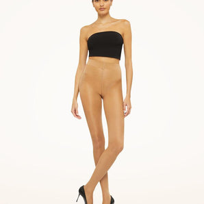 Model wearing Wolford Satin Touch 20 Comfort Tights in gobi showing satin sheen and wide waistband
