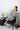 Model lounging in Heather Gray V-neck top