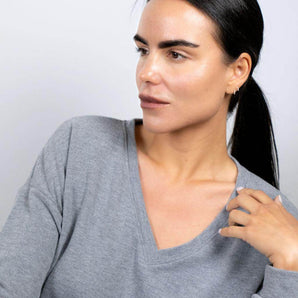 Close up model lounging in Heather Gray V-neck top