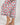 Close-up of cropped pant hem with navy piping trim and berries print