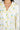 Close-up of notch collar and button placket on ivory pajama top with yellow tennis ball print and yellow piping trim