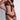 Close-up of black sheer floral lace triangle bra with gold button openings and satin ribbon tie