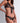 Close-up of black sheer floral lace triangle bra with gold button openings and satin ribbon tie