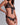 Close-up of black sheer floral lace triangle bra with gold button openings and satin ribbon tie