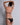 Black sheer bralette and brief with low-cut back and gold hardware detail, back view