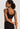 Classic seamless black sports bra in soft ribbed fabric with light support and smooth fit, perfect for everyday comfort.