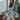 model wearing the Clea short robe by Marjolaine with a wrap front and self-tie belt in white with floral design