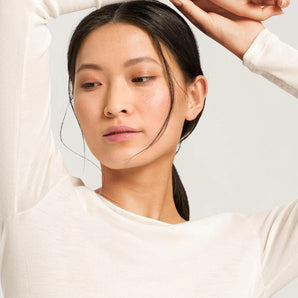 Model wearing a long-sleeve wool-silk thermal top in cygne by Hanro