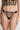 Model wearing the I.D. Sarrieri Love Potion Thong in black featuring embroidered lace, sheer mesh, a low-rise fit, and minimal coverage.