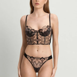 Model wearing the I.D. Sarrieri Love Potion Underwired Half Cup Bustier in black featuring embroidered tulle, stretch silk, underwired half cups, adjustable straps, and a longline silhouette.