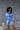 Model wearing Marjolaine Betty Silk Satin Short Robe in Bleu Ciel with crossover neckline and waist belt