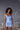 Model wearing Marjolaine Betty Silk Satin Slip in Bleu Ciel showing V-neckline and flowing silk drape