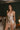 Model wearing the Marjolaine Daisy Floral Silk Nightdress in beige with a delicate floral print, stretch silk satin, floral lace trim, adjustable spaghetti straps, and an above-the-knee silhouette.