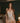 Model wearing the Marjolaine Daisy Floral Silk Nightdress in beige with a delicate floral print, stretch silk satin, floral lace trim, adjustable spaghetti straps, and an above-the-knee silhouette.