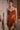 Woman wearing the Marjolaine Diane Dentelle Silk Nightdress in burnt orange with burgundy floral lace.