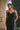 Model wearing the Marjolaine Tess Long Silk Nightdress in black featuring smooth silk satin, floral lace neckline, adjustable spaghetti straps, an ankle-length silhouette, and a side slit.