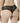 Back view of model wearing black NUEAME Brazilian Flower Lace Briefs showing sheer floral lace back and scalloped edges.