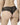 Back view of model wearing black NUEAME Brazilian Flower Lace Briefs showing sheer floral lace back and scalloped edges.