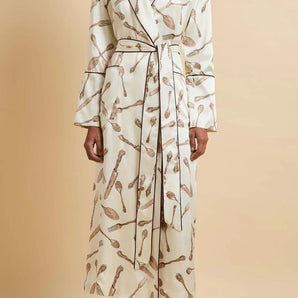Model wearing the Olivia von Halle Capability Sevilla Cream Silverware silk robe featuring the exclusive Silverware print on cream silk satin with burgundy contrast piping and a matching self-tie belt.