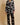 Model wearing the Olivia von Halle Lila Rene Black Blossom silk pajama set featuring the exclusive Blossom floral print on black silk satin with ivory contrast piping.