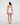 Back view of model wearing Oscalito wool and silk V-neck camisole in ivory with satin trim highlighting seamless construction.