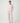 Woman wearing the Pluto Aadia Abelone Pajama Set in soft pink featuring a long sleeve crew neck top and tapered cotton modal pajama pants.