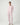 Woman wearing the Pluto Aadia Abelone Pajama Set in soft pink featuring a long sleeve crew neck top and tapered cotton modal pajama pants.
