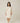 Model wearing Pluto Ebba Cotton Gown in ivory showing long sleeves and lace pocket detail