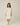 Model wearing Pluto Ebba Cotton Gown in ivory showing long sleeves and lace pocket detail