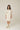 Model wearing Pluto Ebba Cotton Gown in ivory showing long sleeves and lace pocket detail