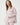 Close-up of dusty pink cotton pajama top chest pocket with striped trim