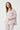 Close-up of dusty pink cotton pajama top chest pocket with striped trim