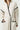 Beige knitted robe with black trim at collar, sleeve, and pocket