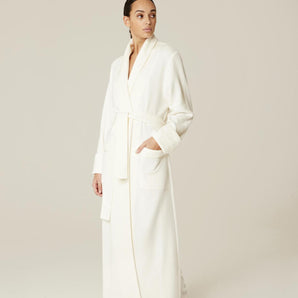 Model wearing Pluto Sylvie long robe in ivory with wrap design, matelassé fabric and belt